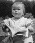 A Literary childhood photo - baby sitting up with a book in her lap
